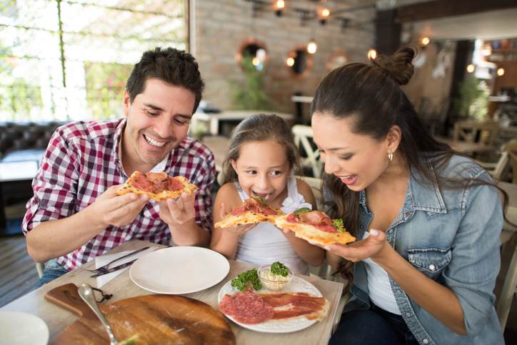 Happy family eating pizza at a restaurant