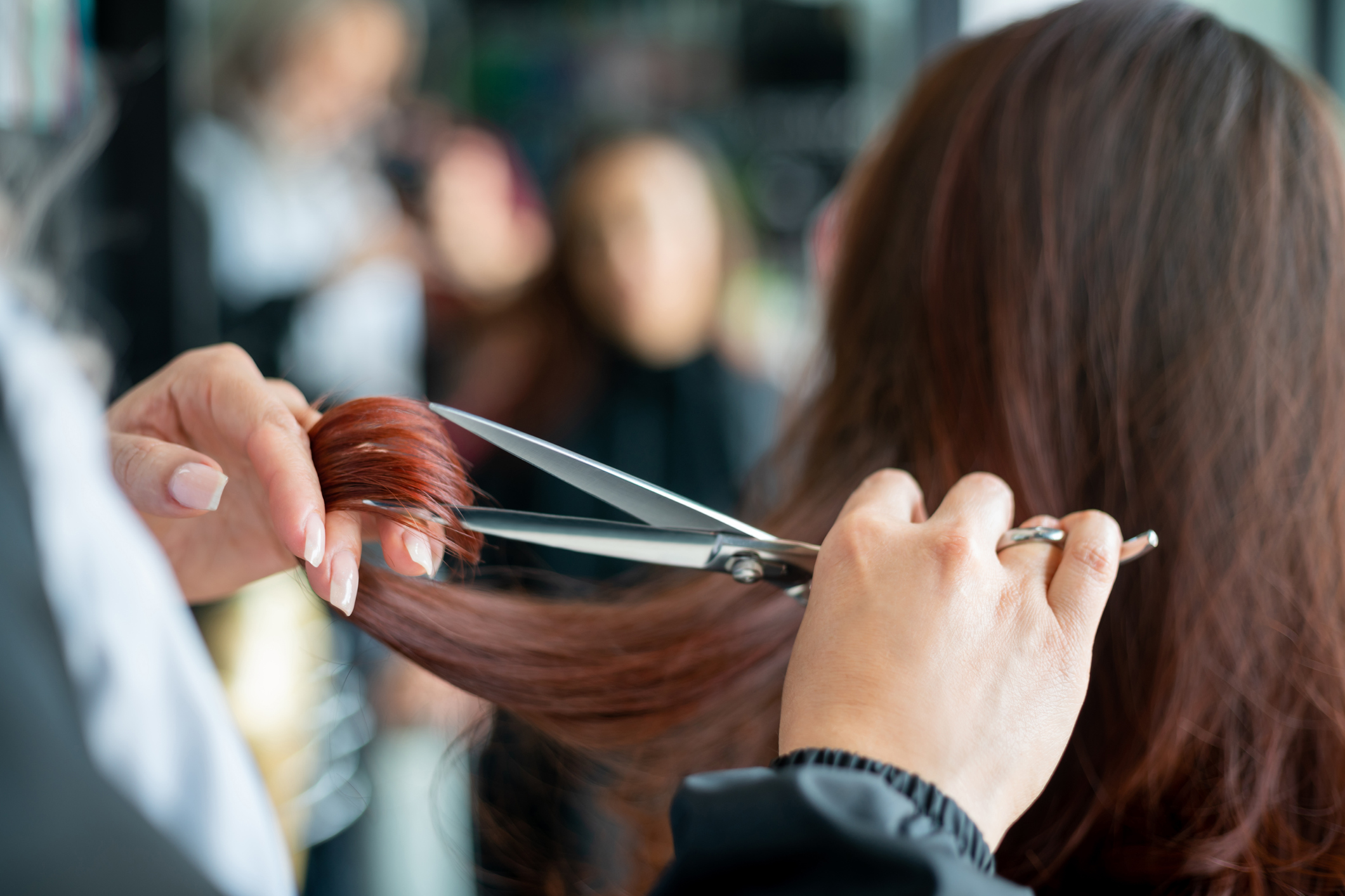 Close up of unrecognizable hairdresser cutting a female customerâs hair